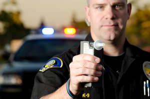 Policeman holding a breathalizer